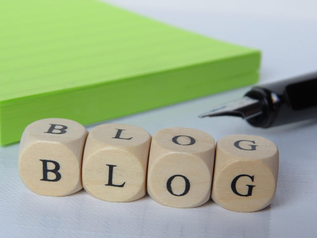 Blocks arranged on a desk that spell out 'blog'.